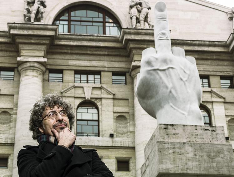 Vito Tartamella davanti alla scultura L.O.V.E. di Maurizio Cattelan esposta di fronte alla Borsa di Milano. (Foto di Elena Datrino)   