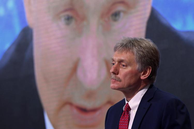 Peskov con dietro  un'immagine di Putin - Afp
