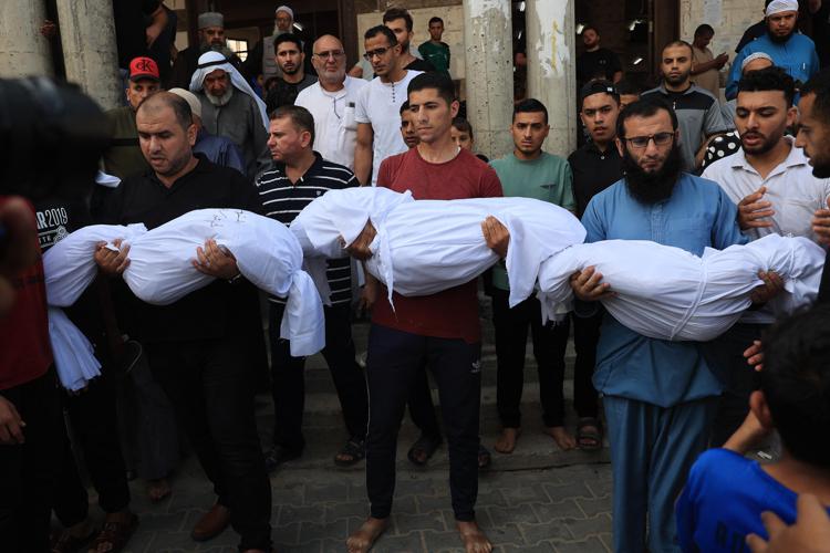 Uomini di Gaza con in braccio i corpi dei figli uccisi - Afp