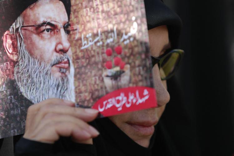 Una donna tiene in mano una immagine del leader degli Hezbollah, Hasan Nasrallah - (Afp)