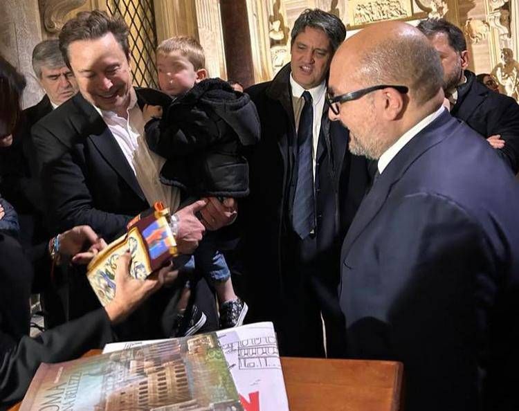 Elon Musk con il figlio in braccio, il direttore dell'Adnkronos Davide Desario e il ministro della Cultura Sangiuliano (Foto Adnkronos)