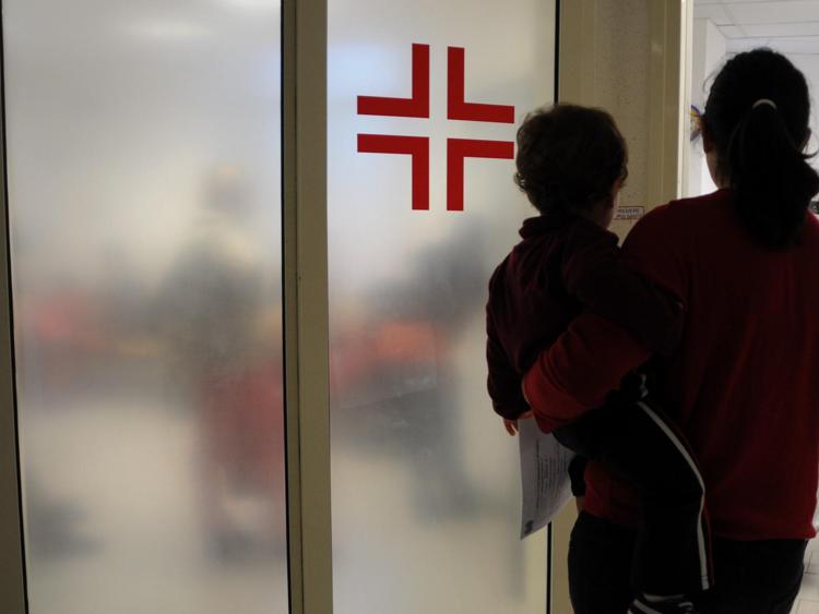 Bambino davanti a porta ospedale - Fotogramma