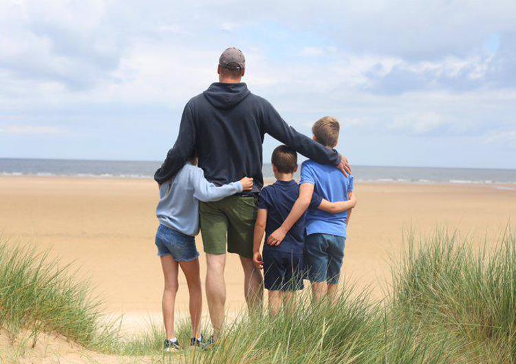 Il principe William di spalle su una spiaggia, che abbraccia i figli - (Foto dal sito ufficiale)