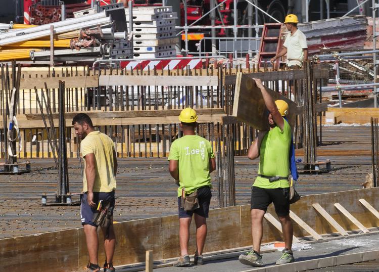 Lavoratori in un cantiere con temperature torride (Fototogramma)