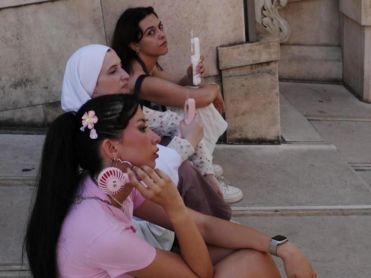 Donne in strada con il ventilatore portatile - Fotogramma