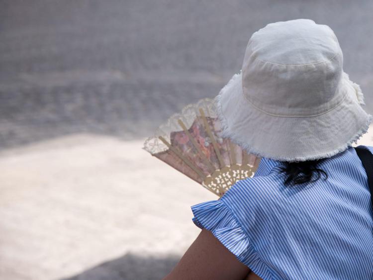 Turista con il ventaglio per il caldo (Fotogramma)