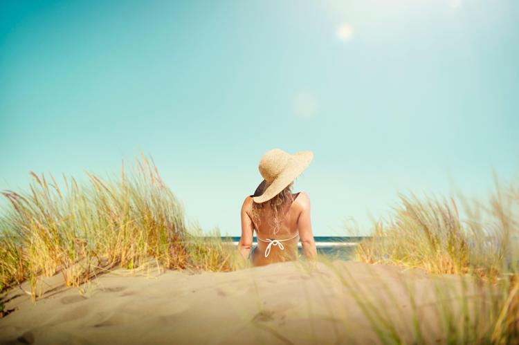 Una donna si abbronza al mare (Foto )