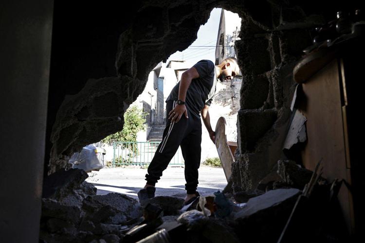 Un uomo palestinese ispeziona una casa danneggiata dopo un raid israeliano notturno nel campo profughi di Balata, a est di Nablus - (Afp)