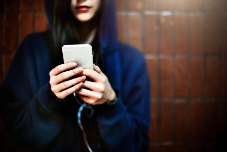 Una ragazza che utilizza uno smartphone - 123Rf