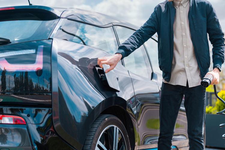 A man recharges an electric car