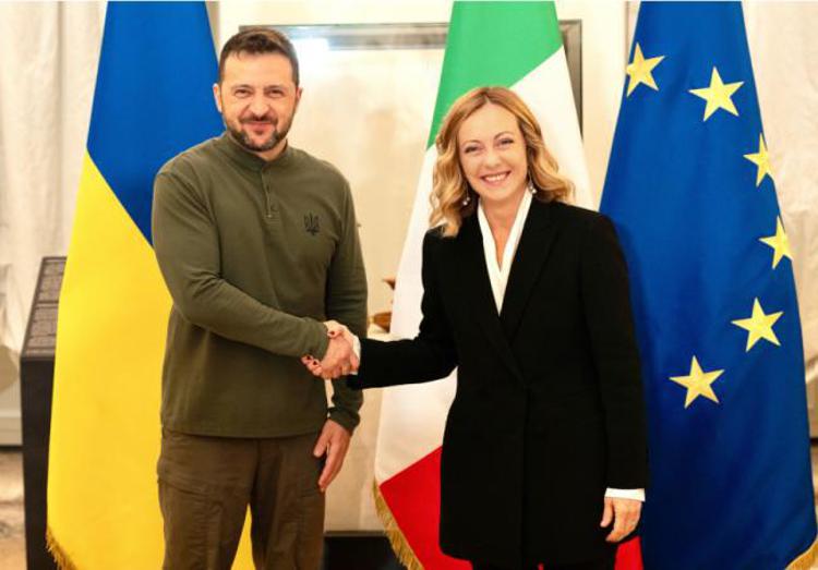 Ukraine's president Volodymyr Zelensky (L) shakes hands with Itay's premier Giorgia Meloni (R)