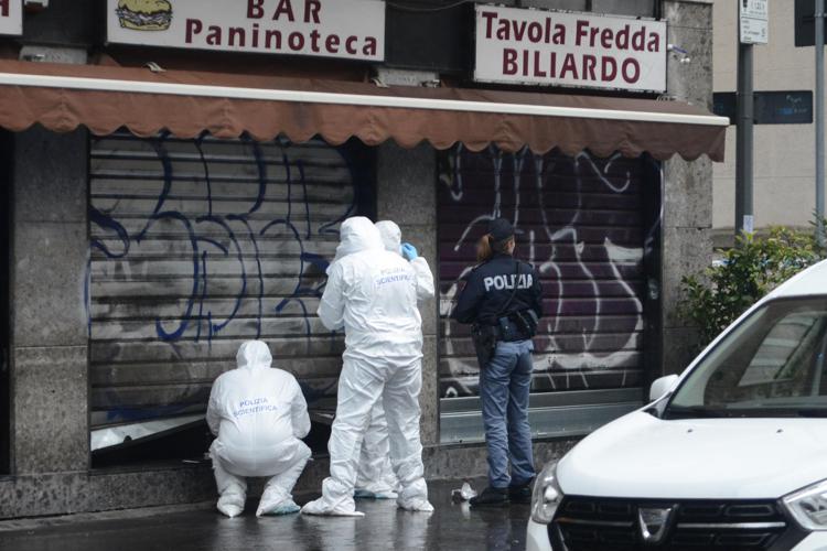 Scientifica al lavoro davanti a bar in viale Giovanni de Cermenate, a Milano - Fotogramma