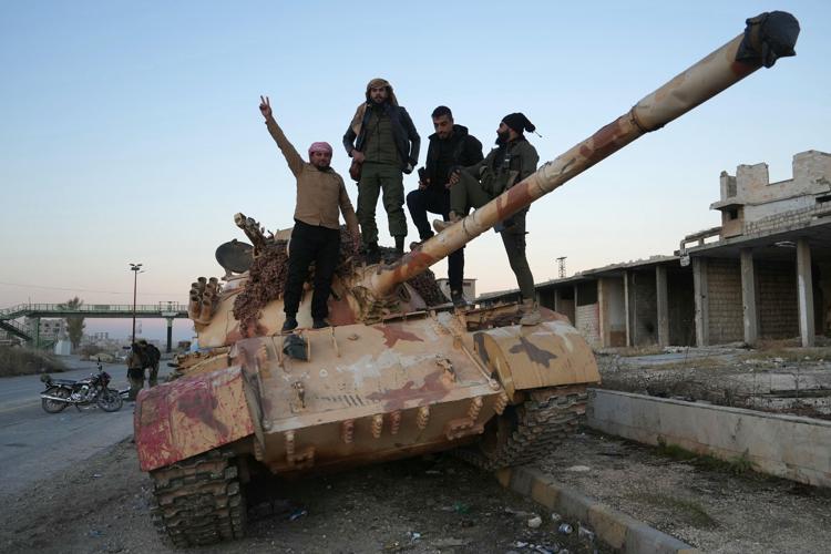 Combattenti antigovernativi posano per una foto su un carro armato - (Afp)